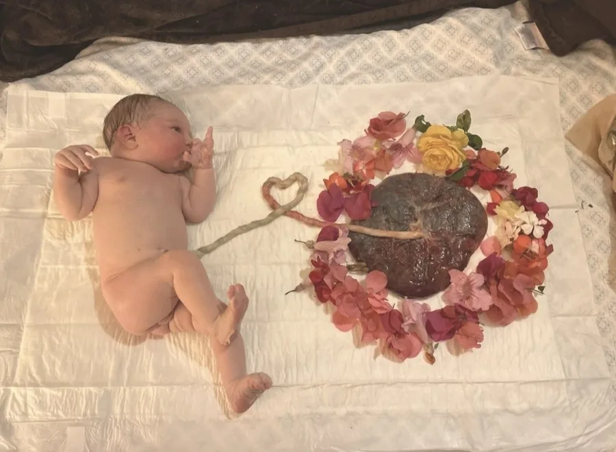 Recién nacido junto a su placenta rodeada de flores