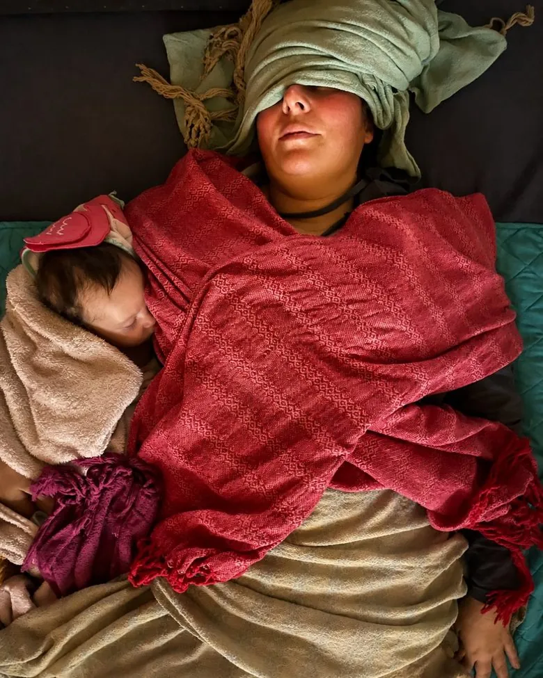 Madre y bebé en reposo, envueltos en rebozo